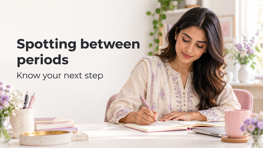 South Asian woman writing a short health note at a home desk, illustrating preparation for a conversation about spotting between periods.